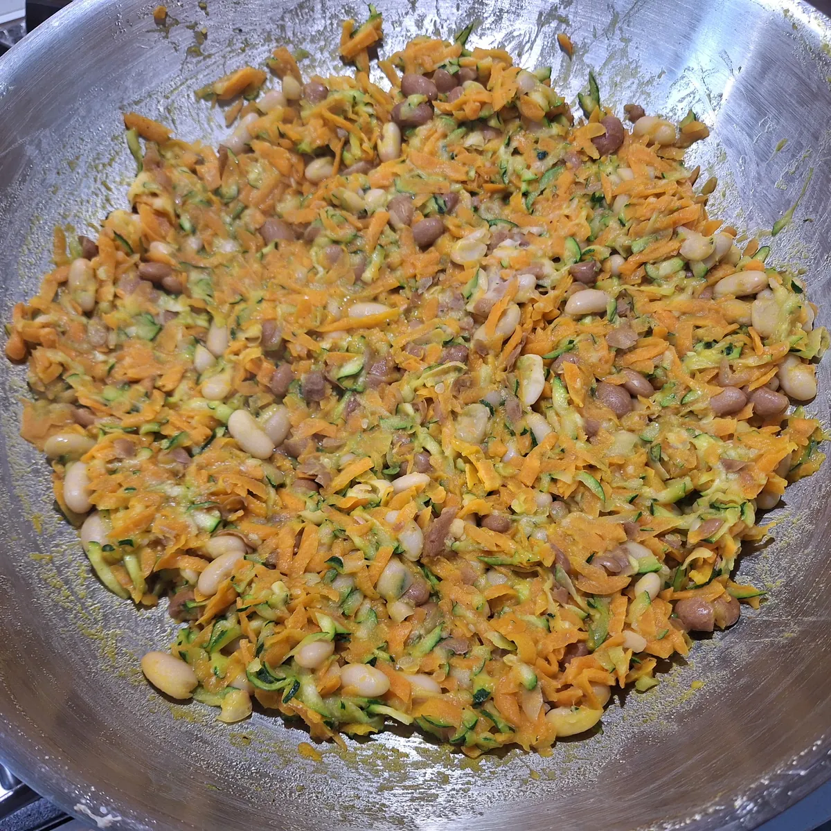 La spadellata in corso: carote, zucchine, fagioli, sale e pepe che si asciugano insieme.