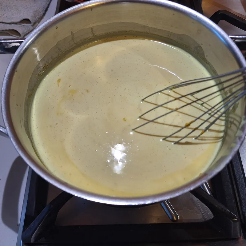 La crema ancora liquida sul fuoco. Si notano ancora le bollicine sulla superficie, segno che la temperatura è ancora bassa.