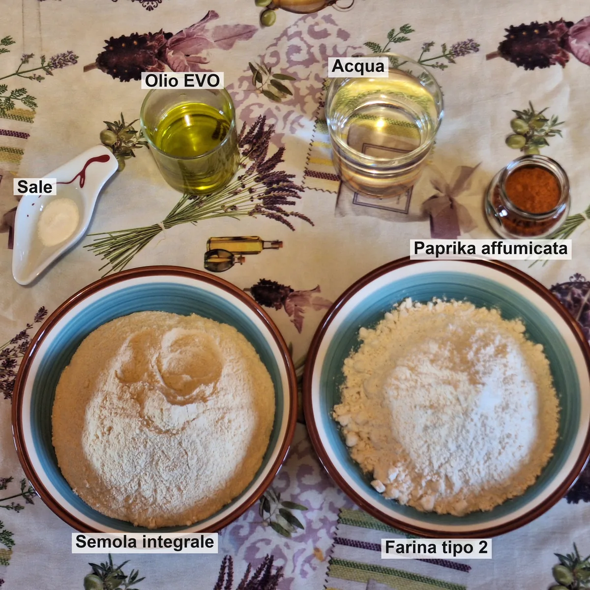 Gli ingredienti della pasta matta: semola integrale e farina tipo 2 nelle due ciotole, olio EVO, acqua, paprika affumicata e sale.