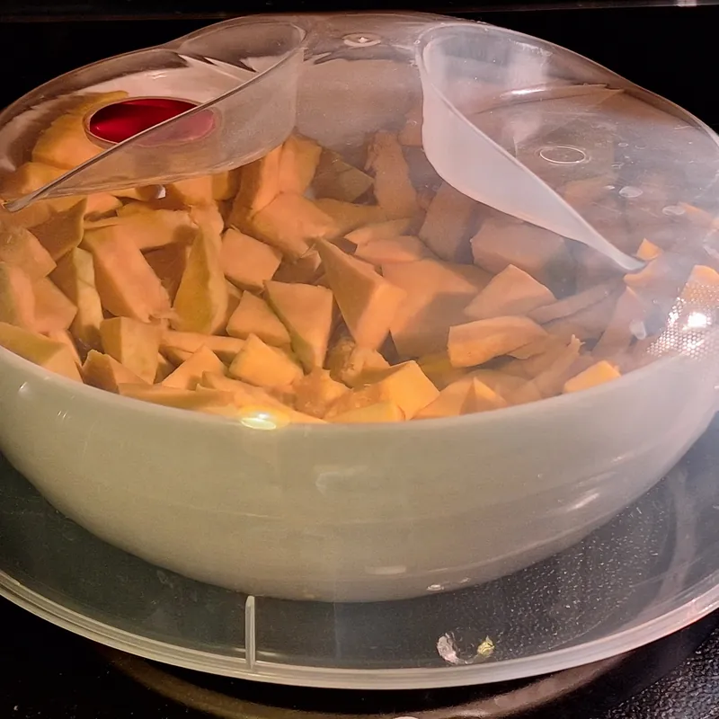 Cottura della zucca al microonde in un contenitore coperto.
