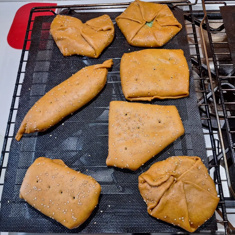 I tortini al parmigiano chiusi, decorati con semi di sesamo bianco, pronti da infornare