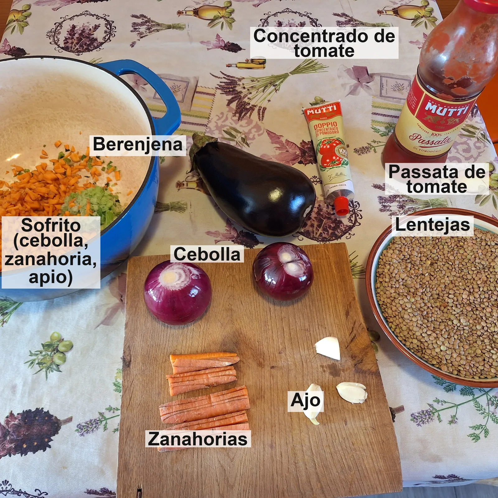 Los ingredientes etiquetados: el sofrito de cebolla, zanahoria y apio en la olla, berenjena, concentrado de tomate, passata, cebolla, zanahorias, ajo y lentejas.